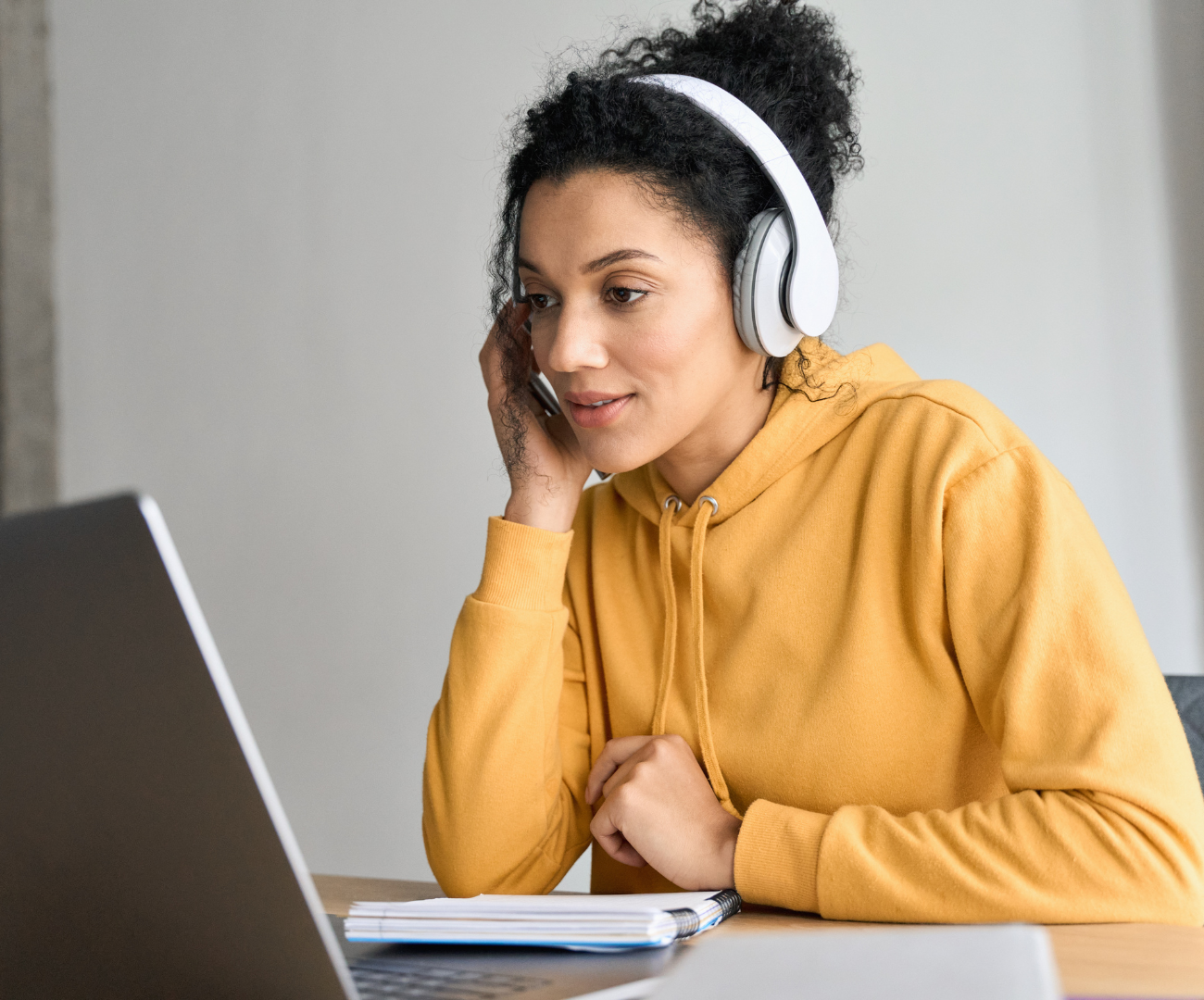 A woman with headphones using a laptop 